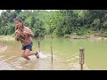 Vietnamese girl alone uses a bamboo basket to catch stream fish and bring it to the market to sell