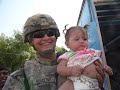 Chris Readling holding a little girl in Iraq 2008/09