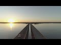 Drone rise between twin bridges at sunset