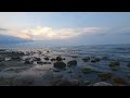 Serene Seascape at Sunset: Mesmerizing Dance of Clouds and Stones by the Sea