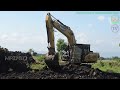 Excavator Working On The  Rice Farm Field Digging The Top Soil For The New Road Construction