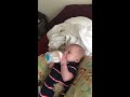Baby Atticus holding his own bottle at 3 months.