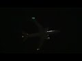 American Airlines Boeing 777-200ER glowing above the nighttime sky