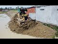 Technique of pouring stone next to the wall across the lake by KOMATSU Dozer with Dump trucks unload
