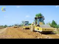 Amazing road construction site with a motor grader leveling the ground, and road rollers to compact.