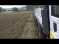 John Deere pulling Ford Transit and trailer up muddy hill