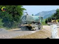 Awesome skillfully maneuvering on a dirt road, construction featuring a yellow road grader in action