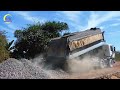 Construction of a road with yellow motor graders & multiple heavy machinery working on a dirt road