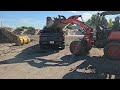 kubota r530 wheel loader with dirt and a Chevy Silverado truck