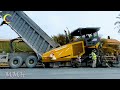 Showing a road construction site with machinery actively paving the road by a paver machine