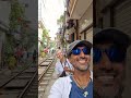 Couple stands by as train passes on Hanoi's famous street